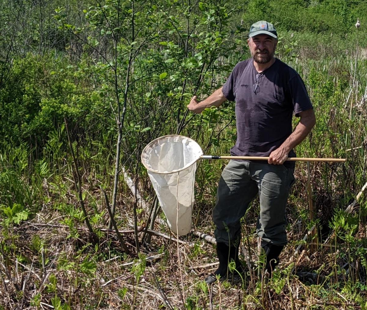 A photograph of forestry researcher Jeff Garnas doing field researcher