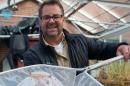 UNH researcher Michael Chambers with a greenhouse-grown shrimp in a net